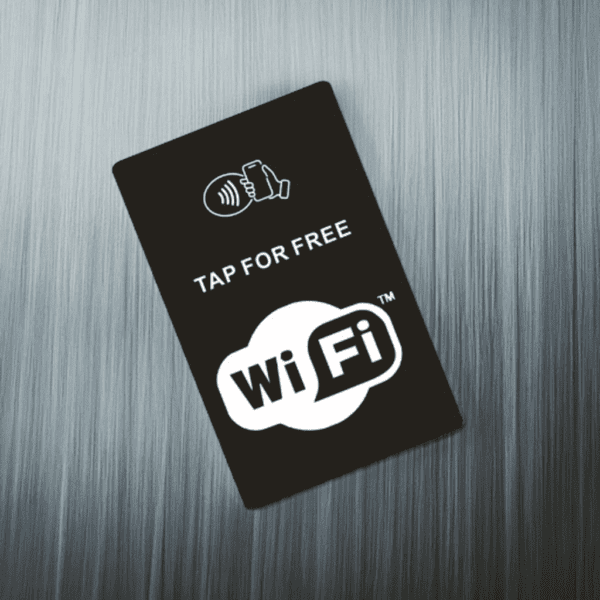 A black sign with a contactless payment symbol and "Tap for Free WiFi" written on it, placed on a brushed metal background.